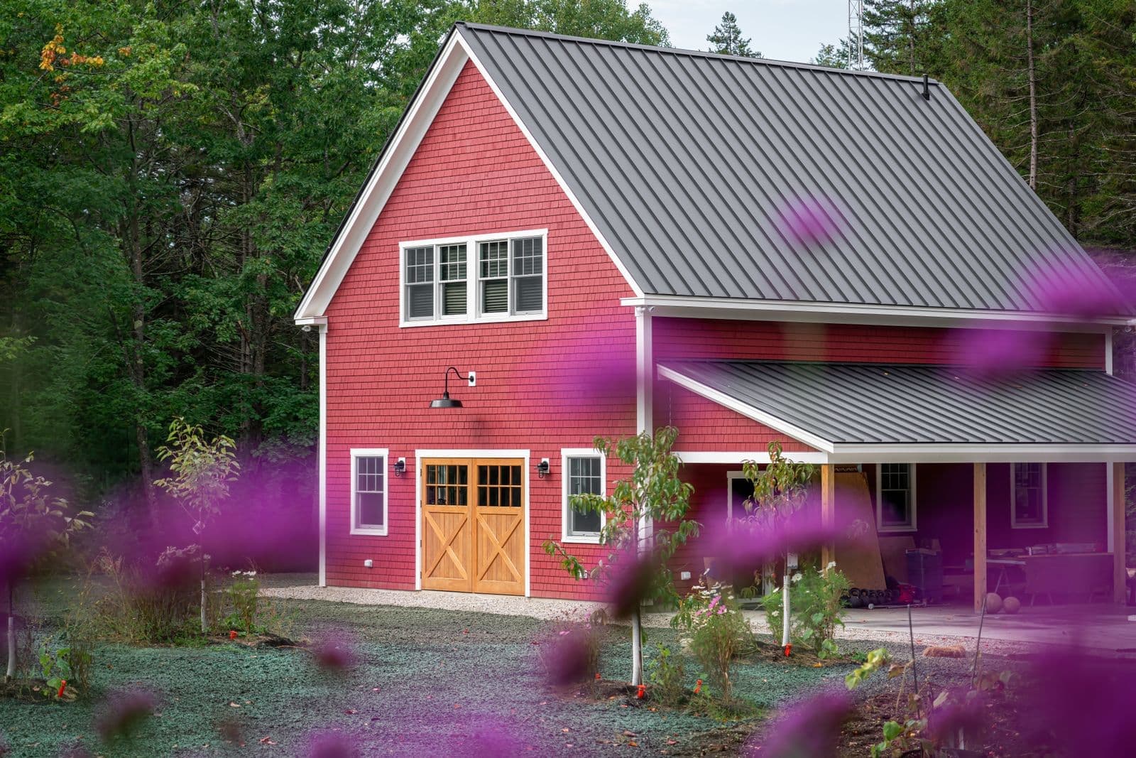 Red two-story house with a gray standing seam metal roof