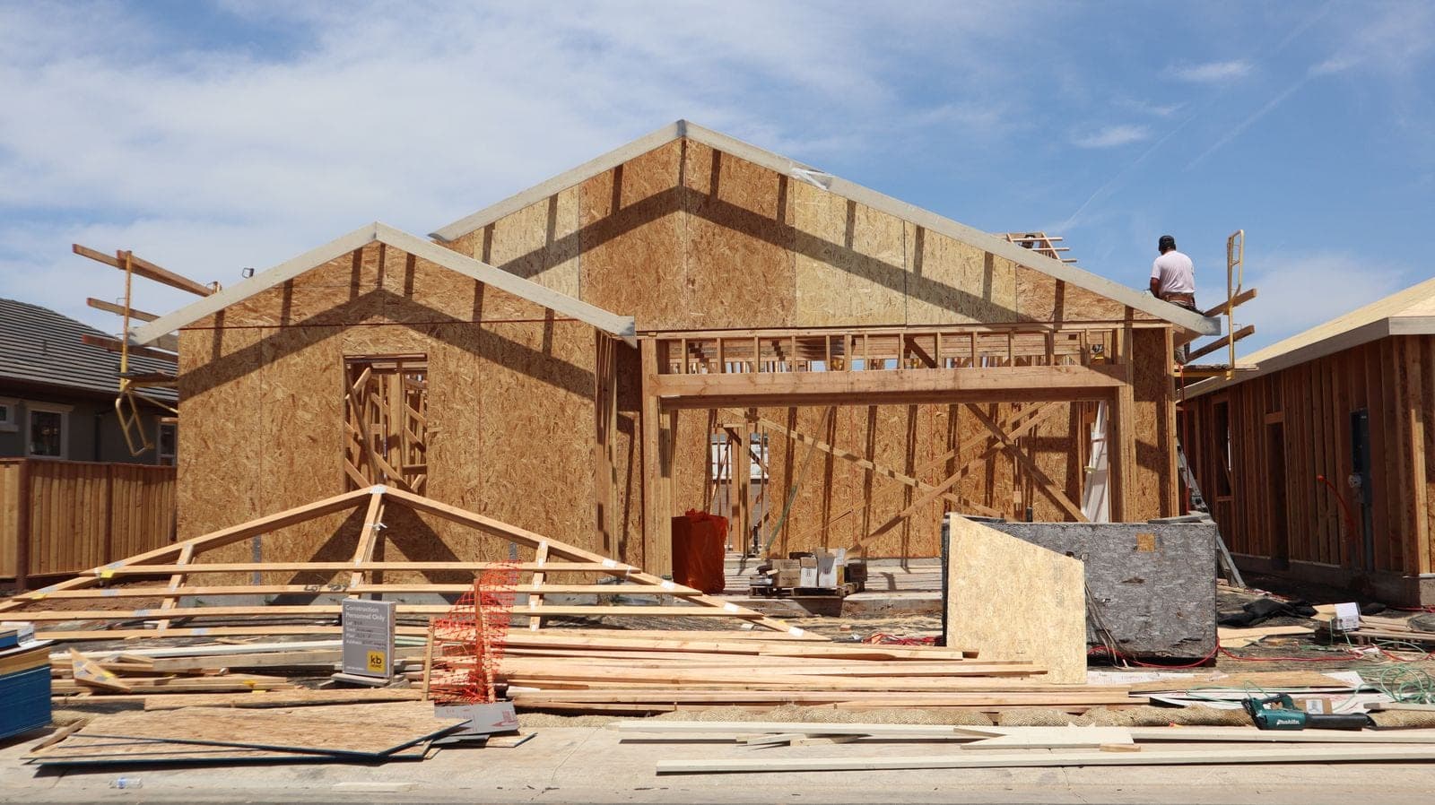 New house framing with roof trusses and sheathing going up
