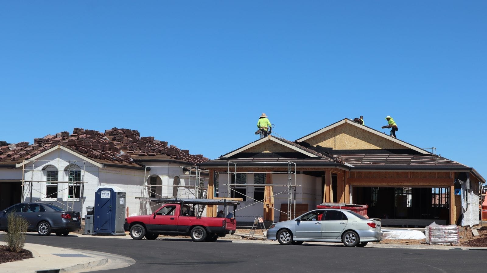 Roofers on top of a house during a full roof replacement