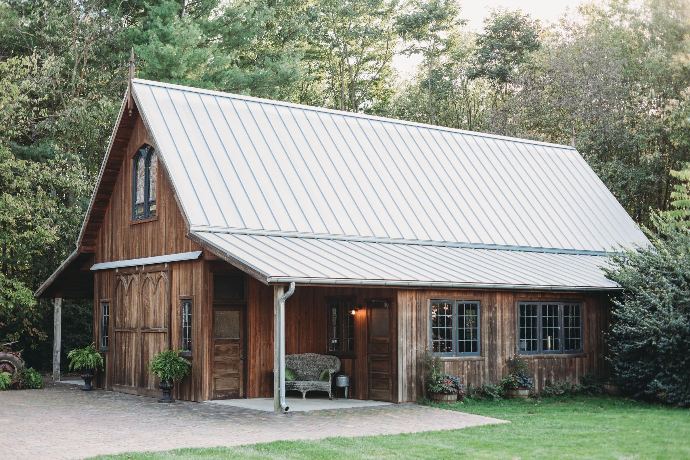Wood-sided barn-style house with a light gray standing seam metal roof